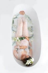 Schwangere im Milchbad mit frischen Blumen bei Schwangerschaftsfotografin in Nürnberg